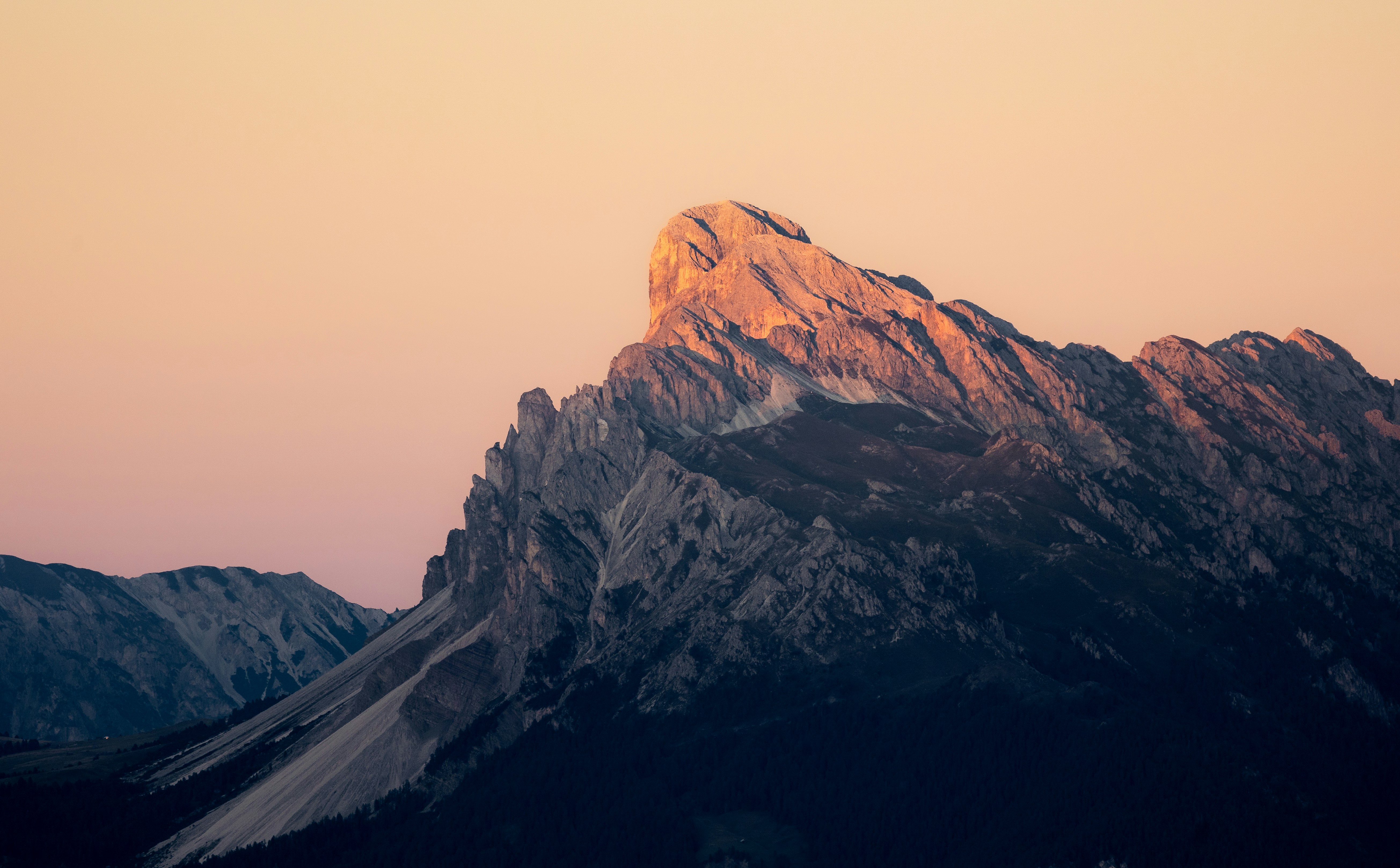 Jagged mountain peak bathed in warm sunset light. (Photo credit: Unsplash)